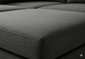 Close-up texture detail of the durable fabric on a dark gray sectional sofa.