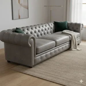 Corner view of a stylish gray leather Chesterfield sectional sofa showcasing the deep button tufting and rolled arms.