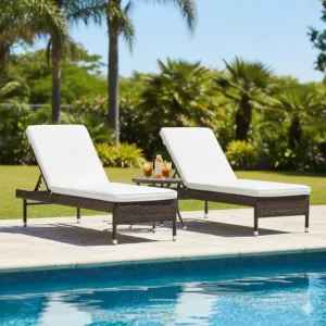 Pair of adjustable resin wicker outdoor furniture chaise lounges positioned next to a swimming pool.