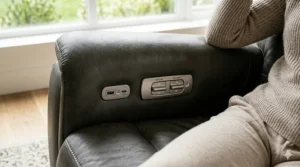 Close-up of a power recliner chair side panel with built-in USB charging ports and buttons.