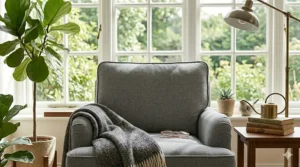 Mid-century modern style comfortable reading armchair with tapered wooden legs and grey fabric.