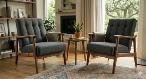 Symmetrical photograph featuring a set of two charcoal grey mid-century modern armchairs arranged as a pair in a sunlit living room.