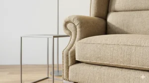 Close-up view of durable beige linen upholstery on a premium quality wingback chair.