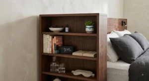 Close-up view of a dark walnut headboard with built-in storage shelves showing neatly arranged bedtime essentials.